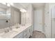 Clean bathroom featuring double sinks, quartz countertops, a glass shower, and ample storage at 5065 Sparkling Water Way, Kissimmee, FL 34746