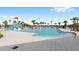 Community pool features a water slide and splash area, surrounded by palm trees and lounge chairs at 5065 Sparkling Water Way, Kissimmee, FL 34746