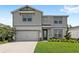 Well-maintained two-story home with manicured lawn, gray siding, and an attached two-car garage offers great curb appeal at 5065 Sparkling Water Way, Kissimmee, FL 34746