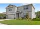 Two-story home with a well-manicured lawn, gray siding, and an attached two-car garage provides great curb appeal at 5065 Sparkling Water Way, Kissimmee, FL 34746