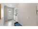 Bright foyer features tiled floors, a decorative mirror, shoe cabinet, and a stylish front door with natural light at 5065 Sparkling Water Way, Kissimmee, FL 34746