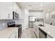 Open kitchen with white cabinetry, stainless steel appliances, ample counter space, and neutral tiled floors at 5065 Sparkling Water Way, Kissimmee, FL 34746