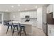 Bright kitchen features white cabinets, stainless steel appliances, an island with seating, and tiled flooring at 5065 Sparkling Water Way, Kissimmee, FL 34746