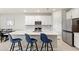 Bright kitchen with white cabinets, stainless steel appliances, a center island with seating, and tiled flooring at 5065 Sparkling Water Way, Kissimmee, FL 34746
