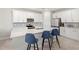 Modern kitchen features white cabinetry, stainless appliances, center island with barstool seating, and stylish tile flooring at 5065 Sparkling Water Way, Kissimmee, FL 34746