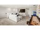Bright living room with a white couch, a flat-screen TV and a shuffleboard table at 5065 Sparkling Water Way, Kissimmee, FL 34746
