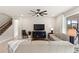 Spacious living room with a ceiling fan, stairs, and comfortable seating arrangement at 5065 Sparkling Water Way, Kissimmee, FL 34746