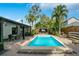 Backyard oasis featuring a sparkling pool, outdoor seating, covered pavilion, and mature tropical landscaping at 6317 Cheryl St, Orlando, FL 32819