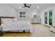 Bright bedroom with white walls, ceiling fan, area rug, and doors leading to the outside at 6317 Cheryl St, Orlando, FL 32819