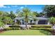 Beautiful single-story home featuring lush landscaping, palm trees, and a circular driveway at 6317 Cheryl St, Orlando, FL 32819