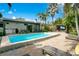 A beautiful rectangular pool is accompanied by a dining area, lounge area, and lush green plants, offering the perfect private retreat at 6317 Cheryl St, Orlando, FL 32819