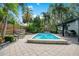 A stunning rectangular pool is surrounded by lush greenery, palm trees and a lounging area with an outdoor kitchen at 6317 Cheryl St, Orlando, FL 32819