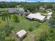 Aerial view of a home with a screened-in patio, mature trees, and a convenient storage shed at 708 Duffer Ln, Kissimmee, FL 34759