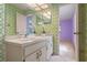 Bathroom vanity with cabinet storage, bright lighting, and decorative wallpaper at 708 Duffer Ln, Kissimmee, FL 34759