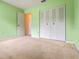 Bedroom featuring a closet, green walls, and neutral carpet at 708 Duffer Ln, Kissimmee, FL 34759