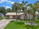 Inviting single-story home featuring a beige exterior, metal roof, and a well-manicured lawn at 708 Duffer Ln, Kissimmee, FL 34759