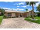 Inviting single-story home featuring a beige exterior, metal roof, and a brick driveway at 708 Duffer Ln, Kissimmee, FL 34759
