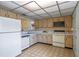 Kitchen featuring wooden cabinets, white appliances, and a view to dining area at 708 Duffer Ln, Kissimmee, FL 34759