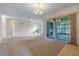 Living room featuring neutral walls, carpet floors, and a sliding door to the patio at 708 Duffer Ln, Kissimmee, FL 34759