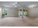 Spacious living room featuring neutral walls, carpet floors, and sliding doors to the enclosed patio at 708 Duffer Ln, Kissimmee, FL 34759