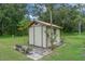 Charming storage shed in a lush backyard setting with attractive landscaping and mature shade trees at 708 Duffer Ln, Kissimmee, FL 34759