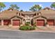 Charming condo building with arched entryways, red garage doors, and lush landscaping at 7421 Sugar Bend Dr # 7421, Orlando, FL 32819