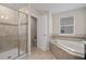 Bright bathroom with tiled shower and separate soaking tub with tiled trim and framed mirror at 9069 Pinch Shot Dr, Winter Garden, FL 34787