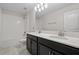 Bathroom features a double sink vanity with dark cabinets and a large framed mirror and shower at 9069 Pinch Shot Dr, Winter Garden, FL 34787