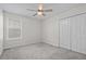 Cozy bedroom with neutral walls, a ceiling fan, closet and a bright window at 9069 Pinch Shot Dr, Winter Garden, FL 34787