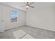 Bright bedroom with neutral walls, ceiling fan, and a sunny window overlooking nearby homes at 9069 Pinch Shot Dr, Winter Garden, FL 34787