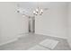 Open dining room with modern chandelier and neutral tile flooring offers abundant natural light at 9069 Pinch Shot Dr, Winter Garden, FL 34787