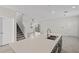 Modern kitchen features a spacious island with a sink overlooking the open living area and staircase at 9069 Pinch Shot Dr, Winter Garden, FL 34787