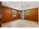Bedroom with paneled walls, tile flooring, a ceiling fan, and natural light from two windows at 9536 Peer Dr, Orlando, FL 32817