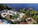 Aerial view of sandy beach with multiple tiki huts, chairs, palm trees, and pier at 1109 New Providence # 141109, Davenport, FL 33897