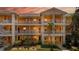 Brightly painted condo building with white railings and lush landscaping shows inviting facade at 1109 New Providence # 141109, Davenport, FL 33897