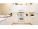 Well-lit kitchen features white cabinets, appliances, and tile flooring at 1109 New Providence # 141109, Davenport, FL 33897