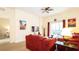Comfortable living room features plush red sofas, ceiling fan, and sliding glass door to balcony at 1109 New Providence # 141109, Davenport, FL 33897