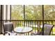 This screened patio is furnished with a round table and two chairs overlooking the community grounds at 1109 New Providence # 141109, Davenport, FL 33897