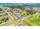 A high-angle view displays a residential area bordered by lush green fields and distant urban amenities at 141 Winsor Ave, Davenport, FL 33837
