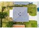 A gray shingled roof of home features vents and a white patio, surrounded by green grass at 141 Winsor Ave, Davenport, FL 33837