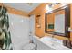 Bathroom featuring a shower-tub combo, a single vanity and a decorative mirror at 141 Winsor Ave, Davenport, FL 33837