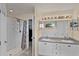 Bright bathroom featuring a double vanity with generous storage, a tiled shower, and decorative lighting at 141 Winsor Ave, Davenport, FL 33837