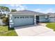 Home exterior featuring a well manicured lawn, brick walkway and driveway, and a two-car garage at 141 Winsor Ave, Davenport, FL 33837