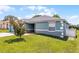 Side view of home showcasing well-maintained lawn, attractive paint color, and brick walkway at 141 Winsor Ave, Davenport, FL 33837