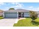 Charming single-story home with a well-manicured lawn, two car garage, and brick walkway at 141 Winsor Ave, Davenport, FL 33837