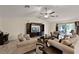 Cozy living room offers neutral paint, tiled floors, large sectional, and access to outdoor patio at 141 Winsor Ave, Davenport, FL 33837