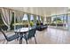 Enclosed sunroom featuring tile flooring, a sitting area, and a table with chairs at 141 Winsor Ave, Davenport, FL 33837