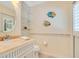 Charming half bathroom with a white vanity, decorative fish art, and mosaic tile accents at 14244 Nottingham Way Cir, Orlando, FL 32828