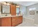 Bathroom with double sink vanity, garden tub, tile floor, and framed mirrors at 14244 Nottingham Way Cir, Orlando, FL 32828