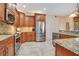Well-equipped kitchen featuring stainless steel appliances, custom wood cabinets, and granite countertops at 14244 Nottingham Way Cir, Orlando, FL 32828